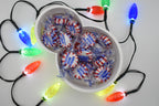 Overhead shot of the Layertreat FrostyBowl 3D printed snowman candy dish filled with wrapped peppermint candies, framed by colorful glowing holiday lights.