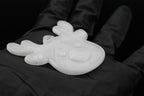 Close up of a 3D printed clear translucent reindeer Christmas ornament resting on a gloved hand against a dark backdrop.