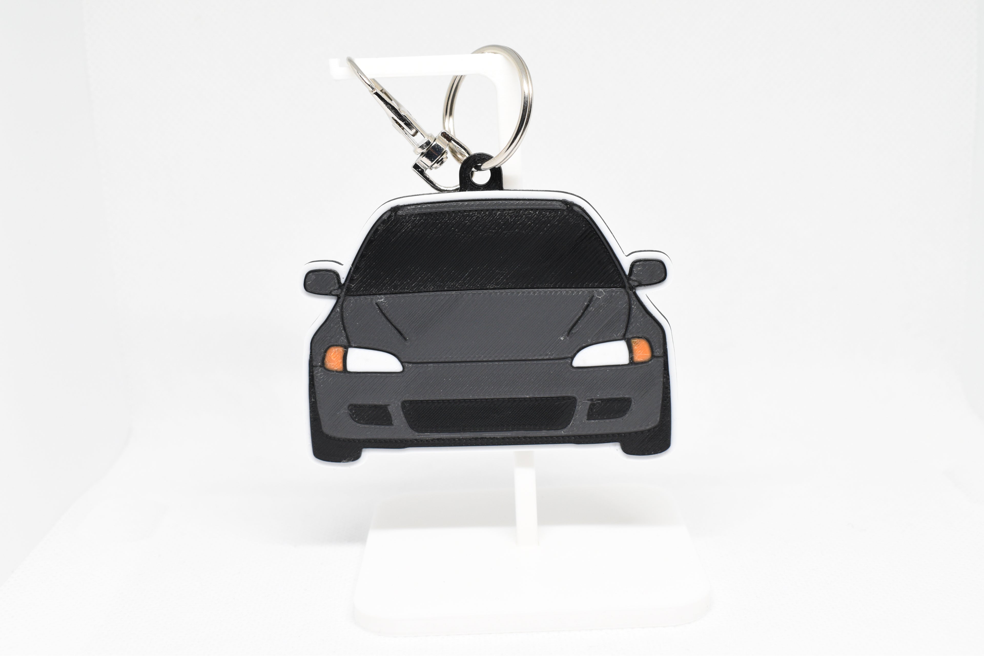 Black EG Civic keychain displayed on a white stand with metal ring and clip.