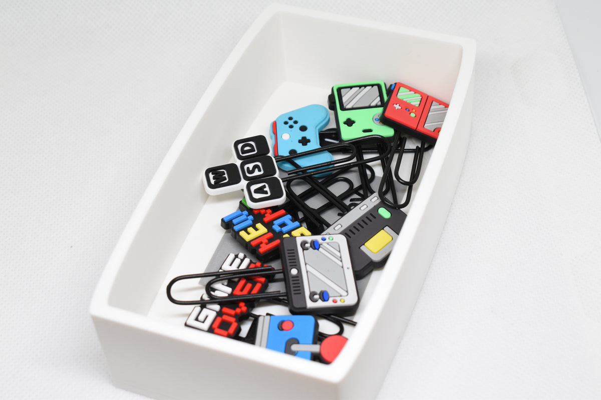Catchall Studio BitTray H1 3D‑printed tray holding assorted retro gaming‑style paperclips arranged on a white background.