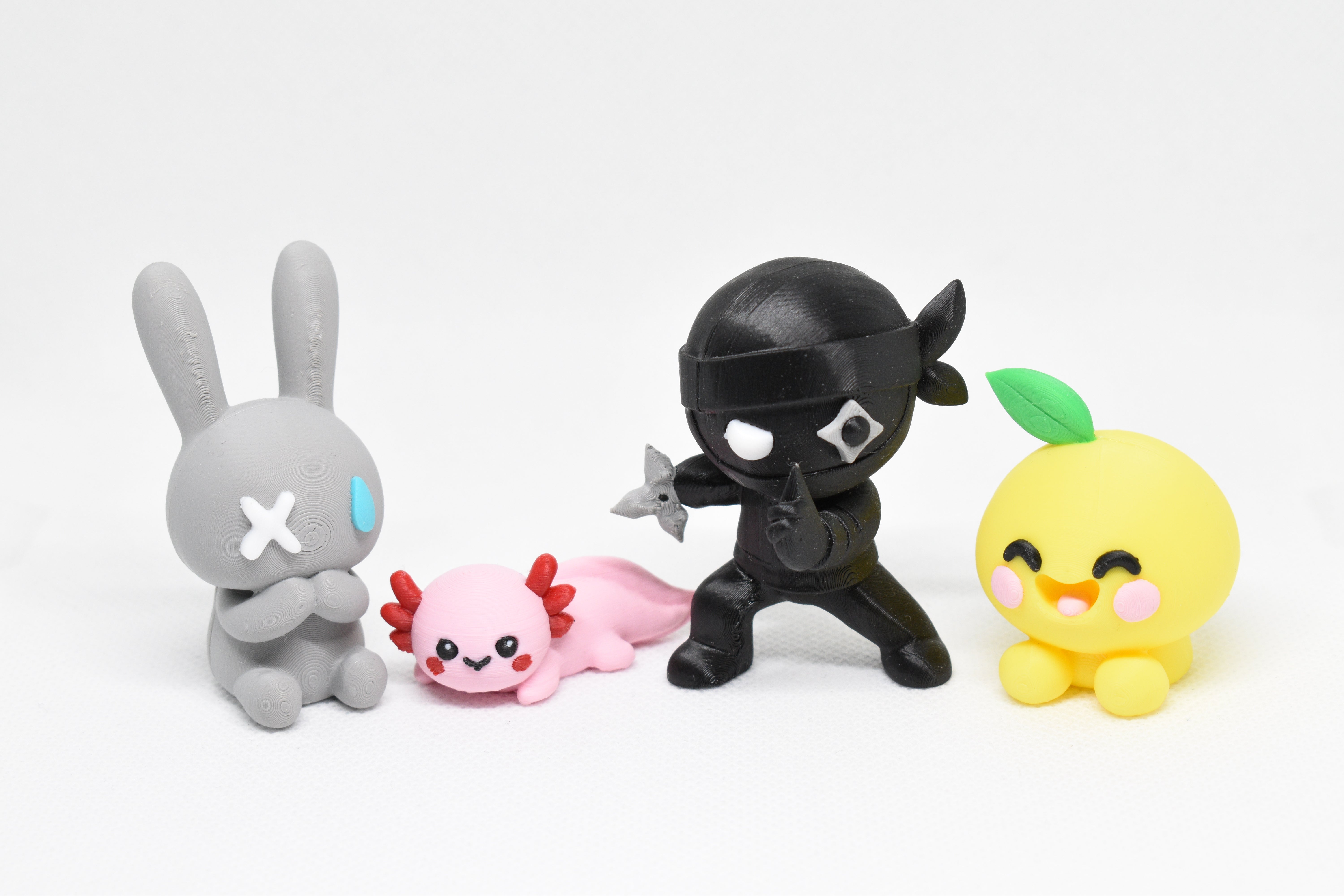Monomoodz Nixie and Shurikid figures displayed alongside Kawaii Axolotl and Lemon characters on a white background.