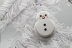 FrostyClick snowman mechanical keyboard switch fidget toy nestled in the branches of a white winter Christmas tree.