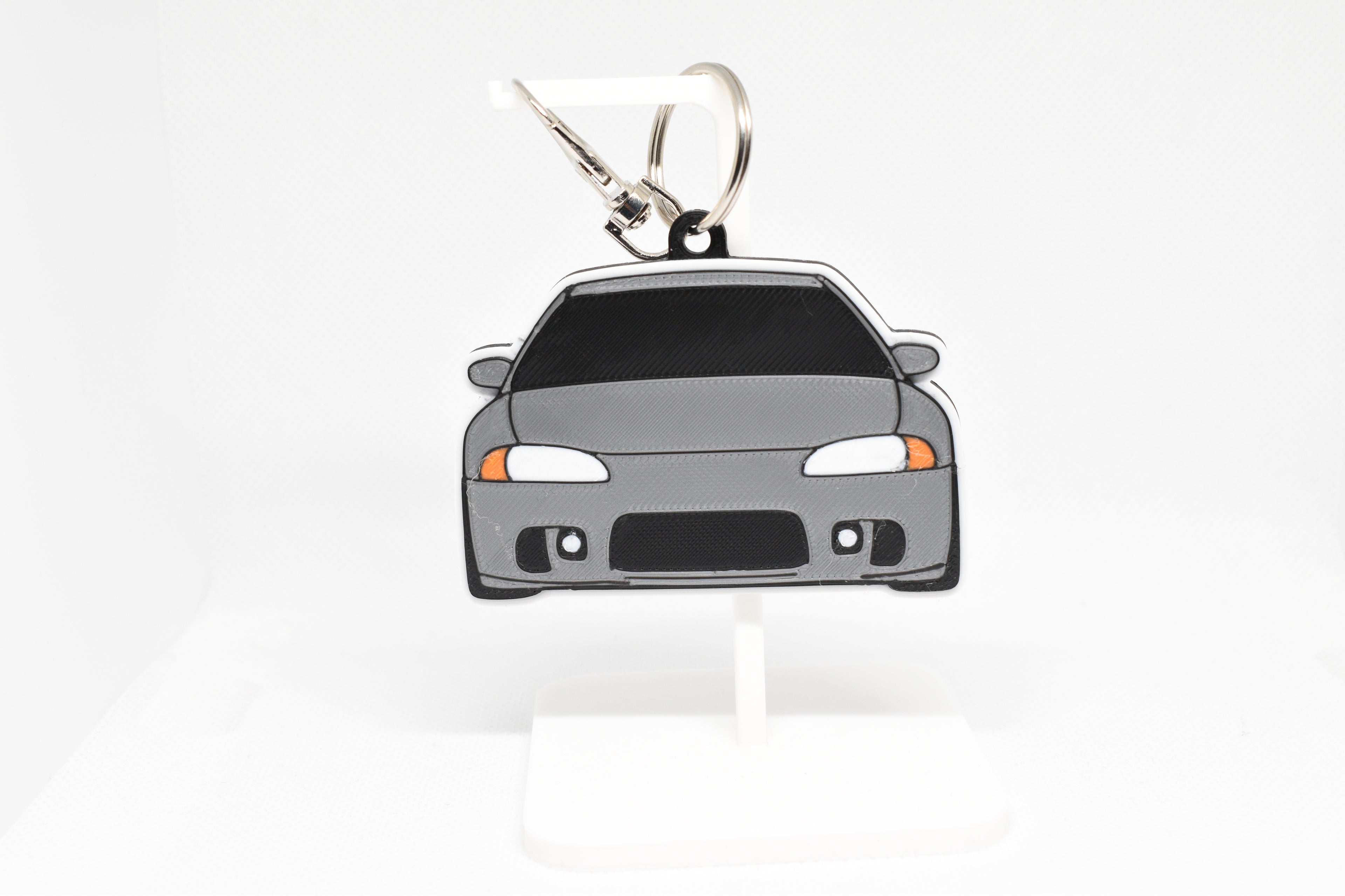 Gray Eclipse keychain displayed on a white stand with metal ring and clip.