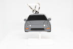Gray Integra keychain displayed on a white stand with metal ring and clip.