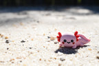 3D printed kawaii axolotl desk toy figurine resting outdoors on beach sand by LayerPlay