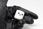 Hand in black glove holding cute 3D printed white kawaii marshmallow desk toy figurine close up by LayerPlay