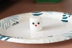 3D printed kawaii marshmallow desk toy figurine sitting on a patterned paper plate display setting by LayerPlay