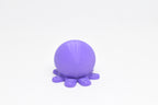 Low angle view of cute 3D printed kawaii octopus desk toy figure resting on a white background by LayerPlay