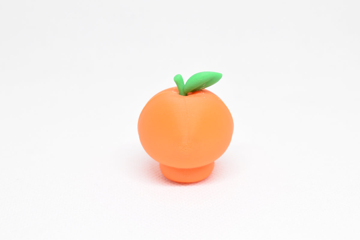 Rear view showing top green leaf texture and smooth finish of orange kawaii orange desk toy figure by LayerPlay