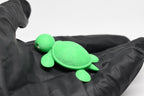 Hand in black glove holding cute 3D printed kawaii sea turtle desk toy figure close up by LayerPlay