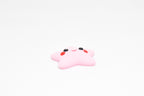 Low angle view of cute 3D printed pink kawaii starfish desk toy figure resting on a white background by LayerPlay