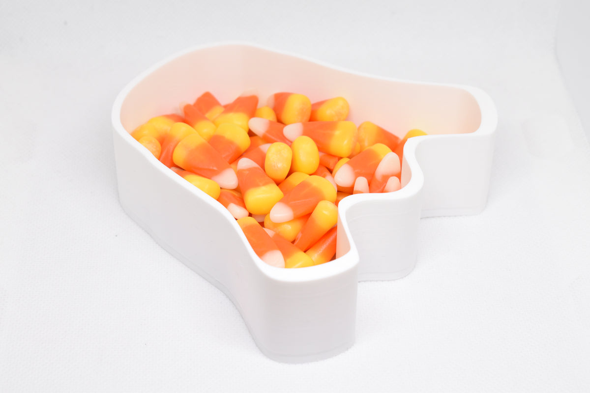 Angled top view of 3D printed white ghost candy dish filled with candy corn for Halloween decor by LayerPlay Layertreat