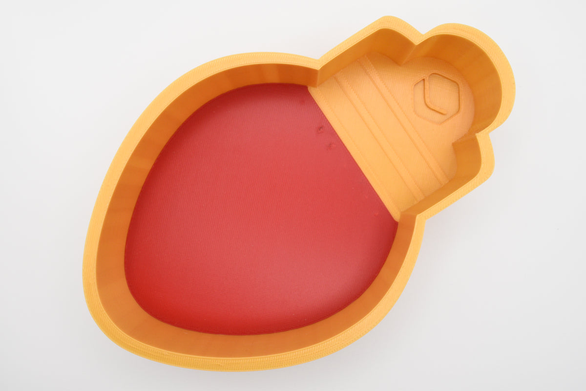Top-down view of the Layertreat BulbBowl, a 3D printed red and gold retro Christmas light bulb candy dish on a clean white background.