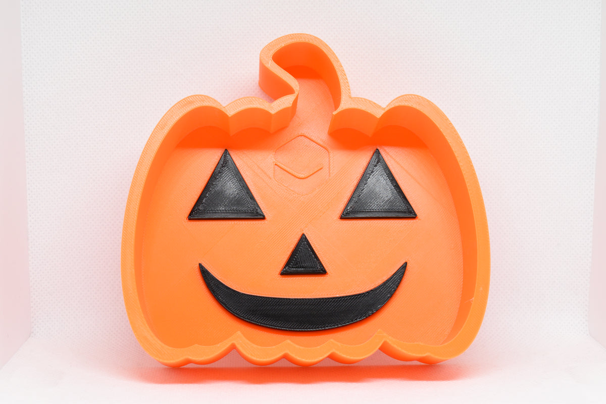 Top studio view of 3D printed orange octagonal JackBowl candy dish featuring orange jack-o'-lantern design by LayerPlay Layertreat