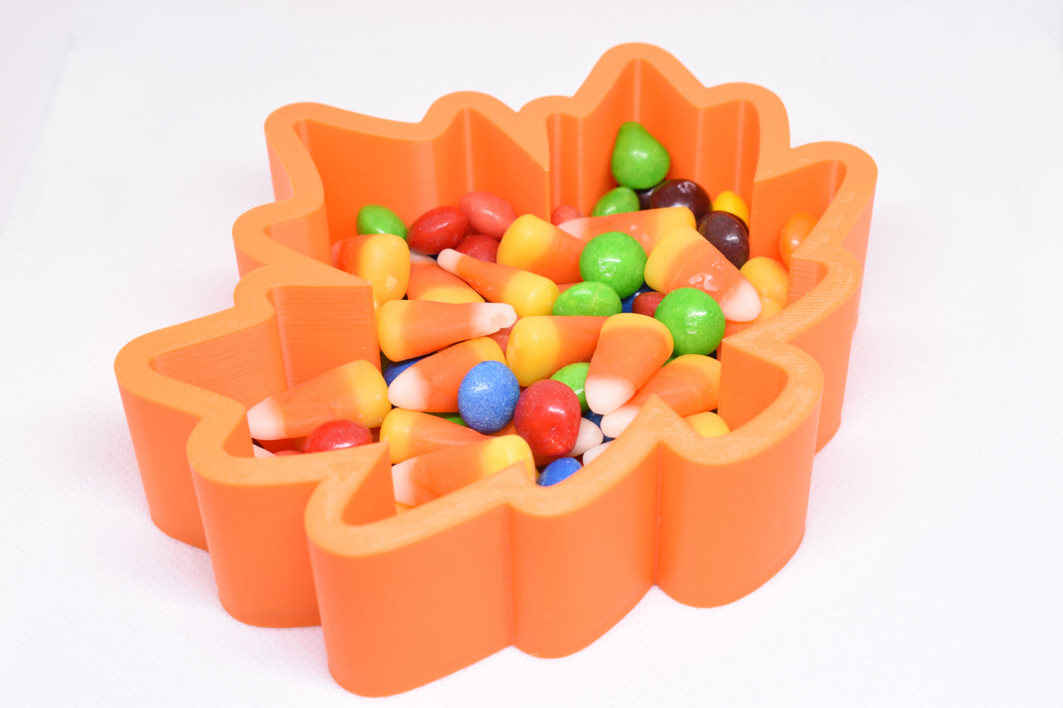 Angled top view of 3D printed orange maple leaf candy dish filled with candy corn and Skittles by LayerPlay Layertreat