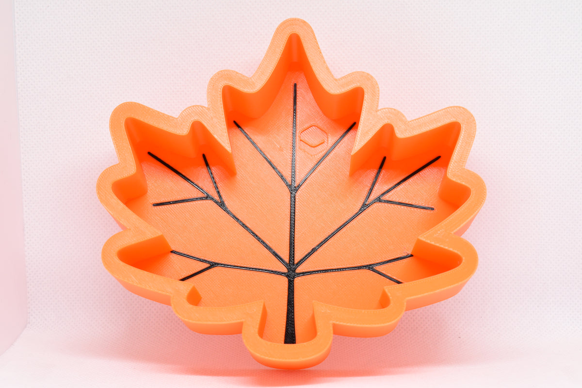 Front studio view showing 3D printed orange maple leaf design with black vein details on MapleBowl candy dish by LayerPlay Layertreat