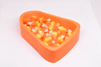 Angled studio view of 3D printed candy corn shaped dish filled with candy corn for Halloween decor by LayerPlay Layertreat