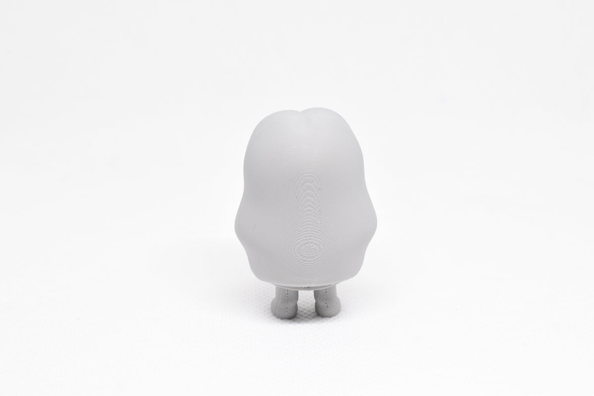 Rear view showing long flowing hair texture and silhouette of grey 3D printed monomoodz corra collectible figure by LayerPlay