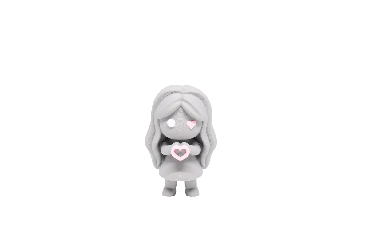 3D printed grey monomoodz corra desk figure holding a pink heart with long wavy hair, white circle eye, and pink heart eye front view by LayerPlay