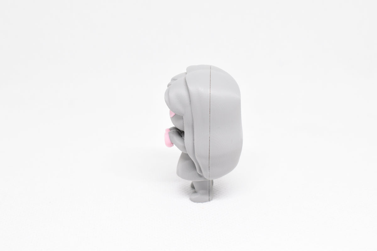 Side profile view showing long wavy hair back and held heart pose of 3D printed monomoodz corra desk figure by LayerPlay