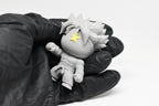 Hand in black glove holding 3D printed grey monomoodz erix martial arts desk figure close up by LayerPlay