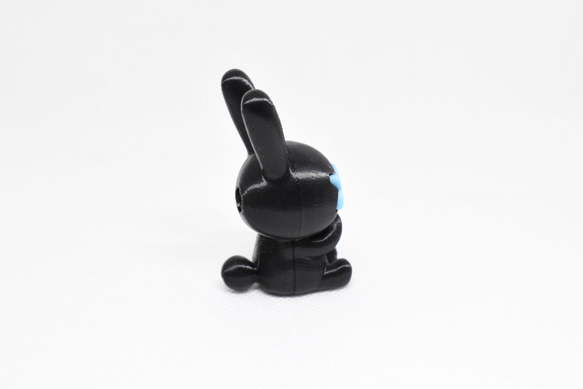 Side profile view showing black body, tall rabbit ears, and glow in the dark blue eye detail of 3D printed monomoodz nixie desk figure by LayerPlay