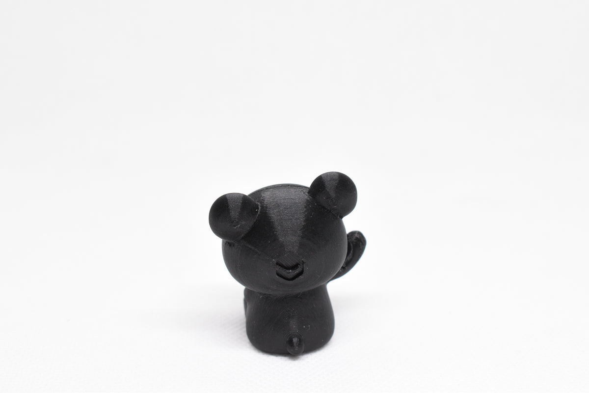 Rear view showing rounded bear ears and small tail of black 3D printed monomoodz glow in the dark twinkle figure by LayerPlay
