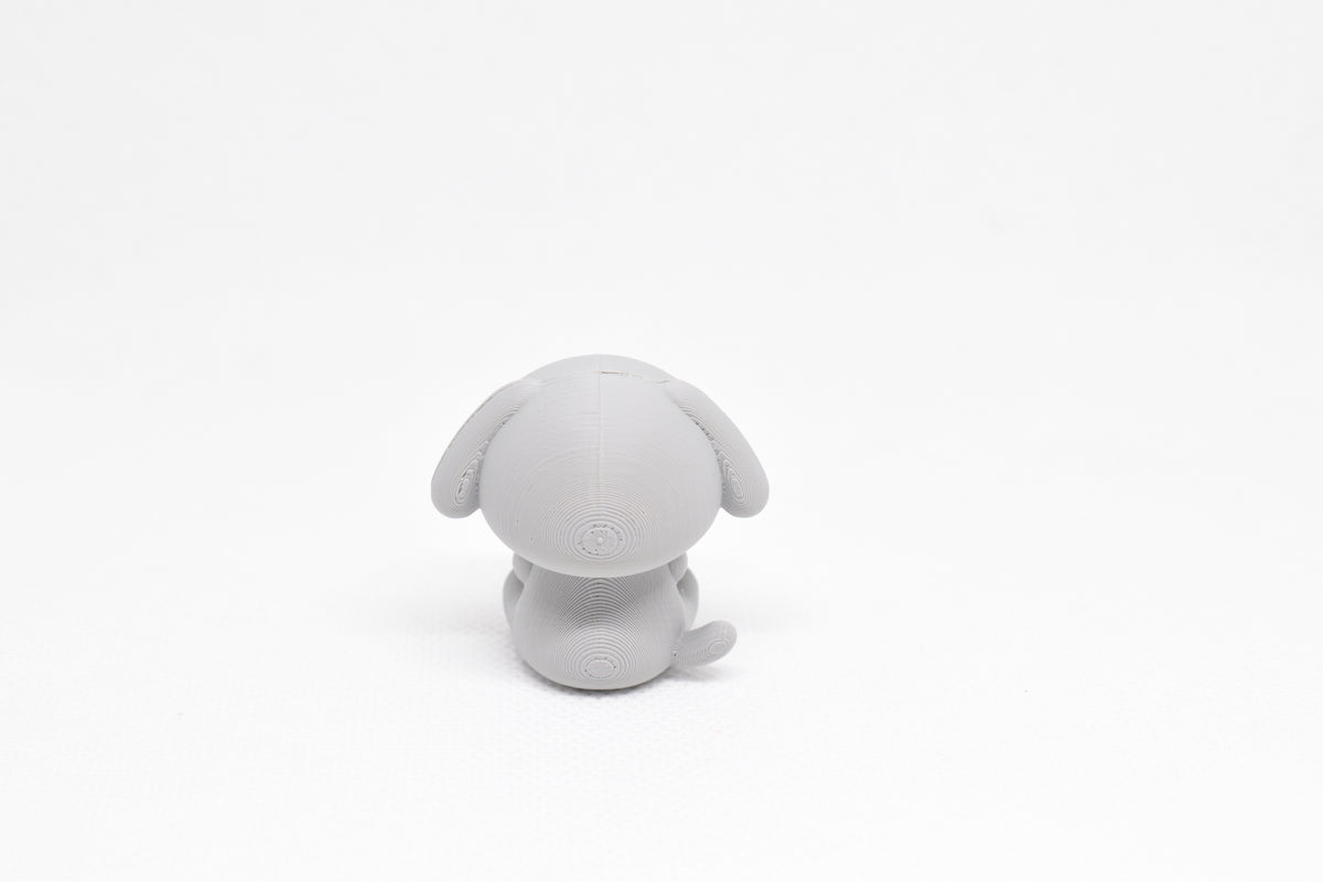 Rear view showing floppy dog ears and tail profile of grey 3D printed monomoodz glyphie collectible figure by LayerPlay