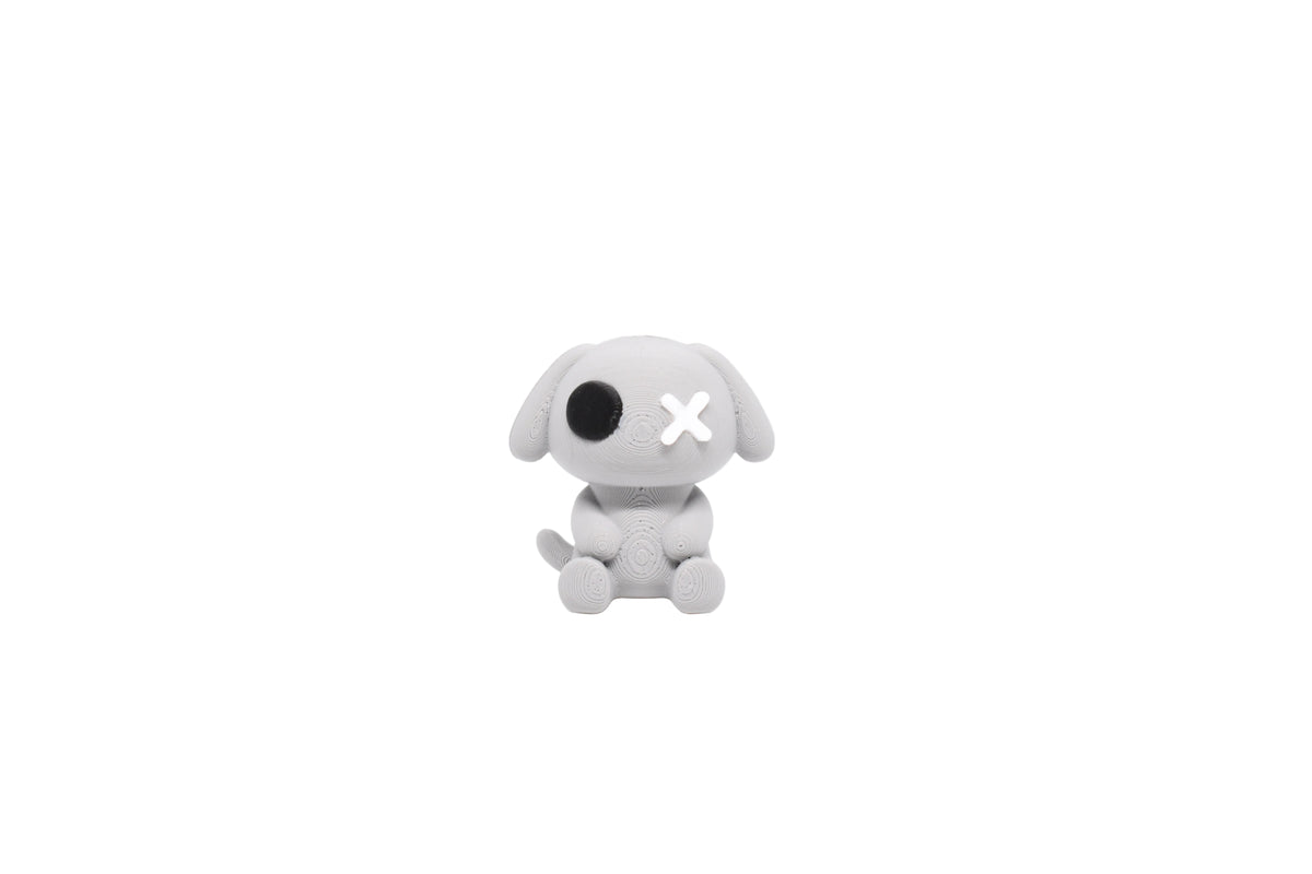 3D printed grey monomoodz glyphie dog desk figure with black circle eye, white X eye, floppy ears, and sitting pose front view by LayerPlay