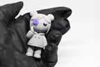 Hand in black glove holding cute grey 3D printed monomoodz kiri desk figurine close up by LayerPlay