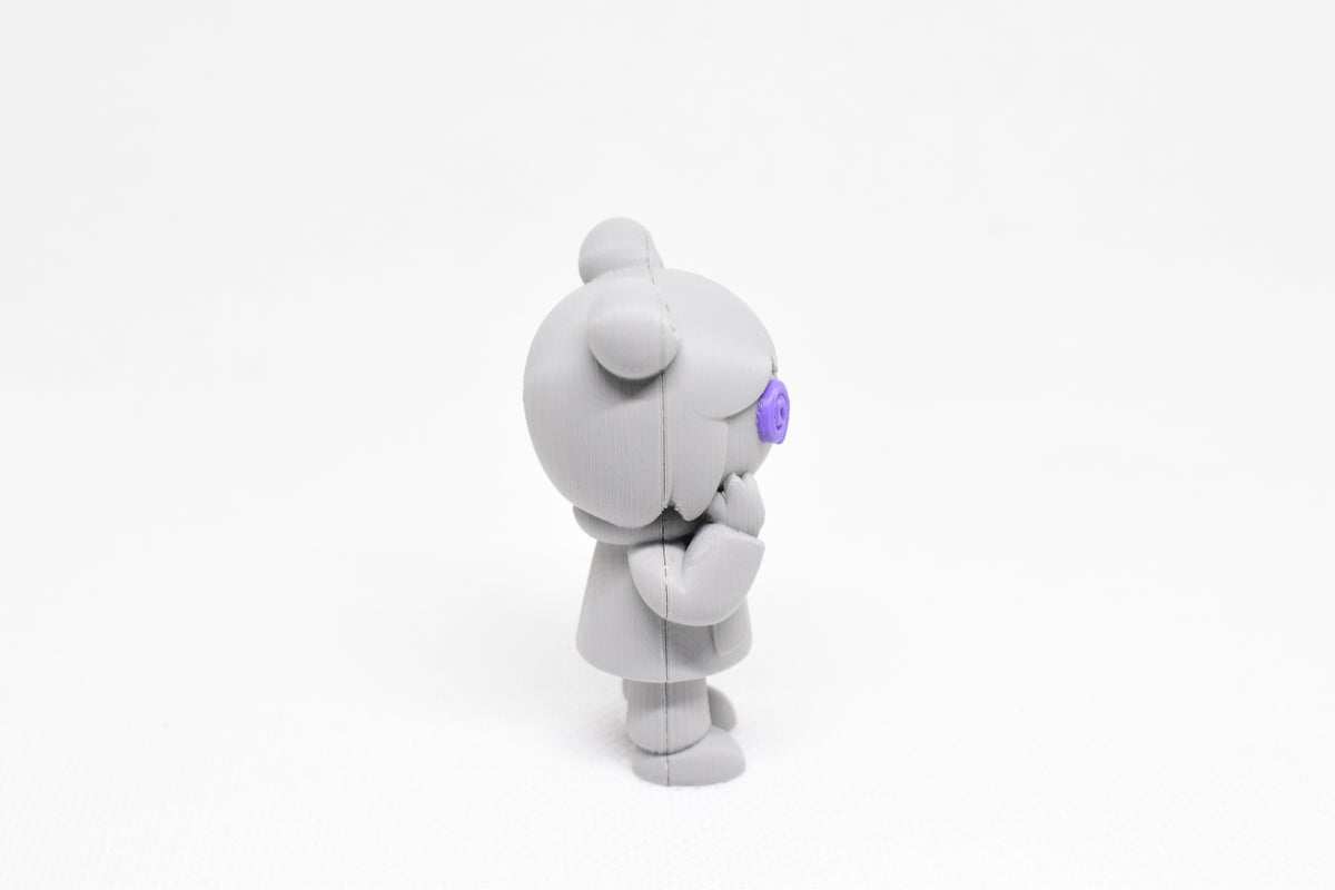 Side profile view showing raised purple spiral eye and hoodie details of 3D printed monomoodz kiri desk figure by LayerPlay