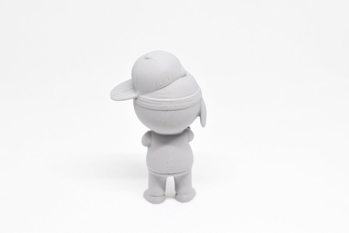 Rear view showing cap strap detail, angled hat brim, and streetwear stance of grey 3D printed monomoodz lil static collectible figure by LayerPlay
