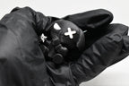 Hand in black glove holding 3D printed black monomoodz ninja glyphie dog figure holding a mini shuriken close up by LayerPlay