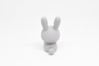 Rear view showing tall rabbit ears and fluffy tail of grey 3D printed monomoodz nixie collectible figure by LayerPlay