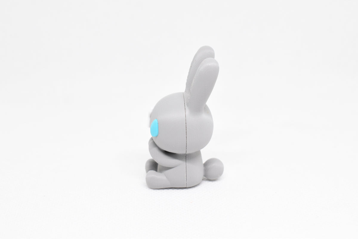 Side profile view showing round bunny tail and blue teardrop eye detail of 3D printed monomoodz nixie desk figure by LayerPlay