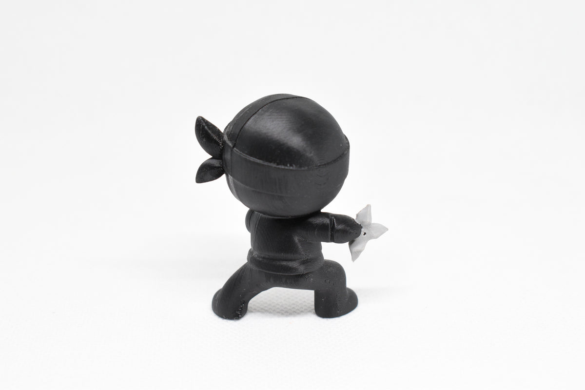Rear view showing ninja cowl, headband tie, and low action stance of black 3D printed monomoodz shurikid collectible figure by LayerPlay