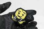Hand in black glove holding 3D printed pixel 6 7 emoji keychain front view detail by LayerPlay
