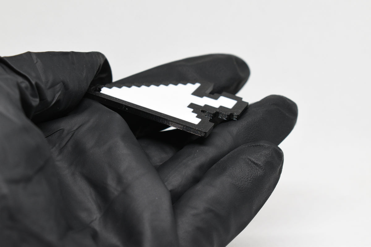 Side angle view showing 3D layered pixel detail and thickness of pixelated arrow cursor keychain by LayerPlay