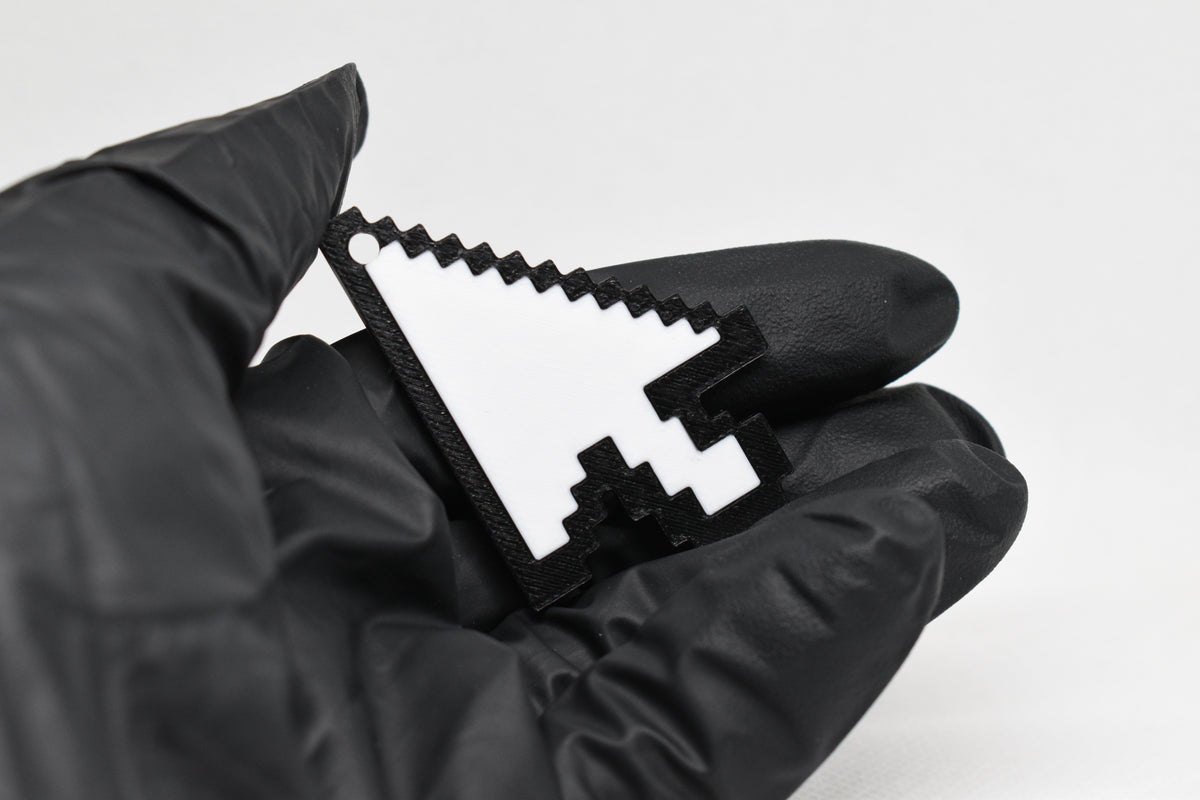 Hand in black glove holding 3D printed retro pixel arrow cursor keychain front view detail by LayerPlay