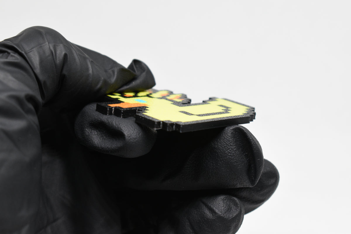 Side angle view showing 3D layered pixel detail and thickness of Ascended Duck pixel rubber duck keychain by LayerPlay