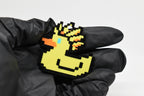 Hand in black glove holding 3D printed retro Ascended Duck pixel rubber duck keychain front view detail by LayerPlay