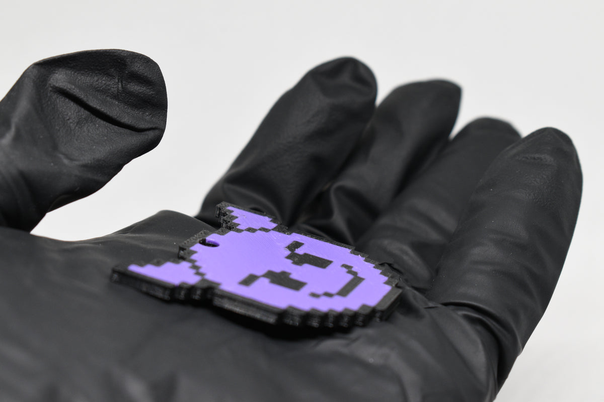 Side angle view showing 3D layered pixel detail and thickness of pixelated devil emoji keychain by LayerPlay