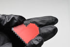 Hand in black glove holding 3D printed pixel heart emoji keychain front view detail by LayerPlay