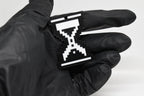 Hand in black glove holding 3D printed retro pixel hourglass cursor keychain front view detail by LayerPlay