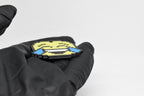 Side angle view showing 3D layered pixel detail and thickness of pixelated laughing emoji keychain by LayerPlay