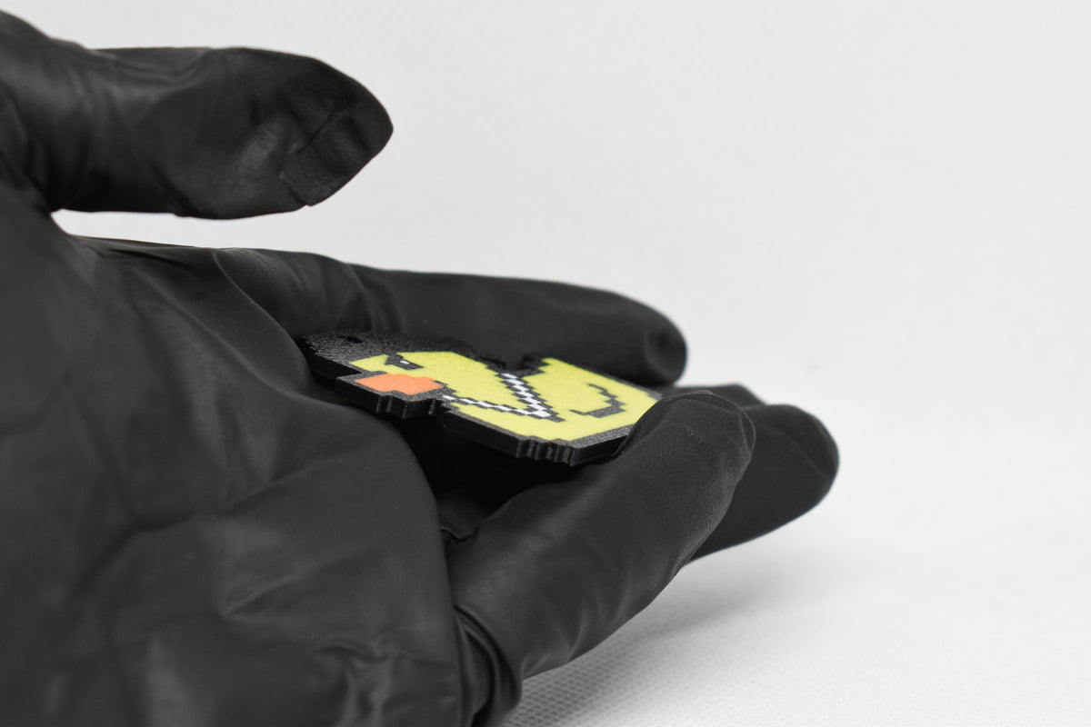 Side angle view showing 3D layered pixel detail and thickness of Lil Quack pixel rubber duck keychain by LayerPlay