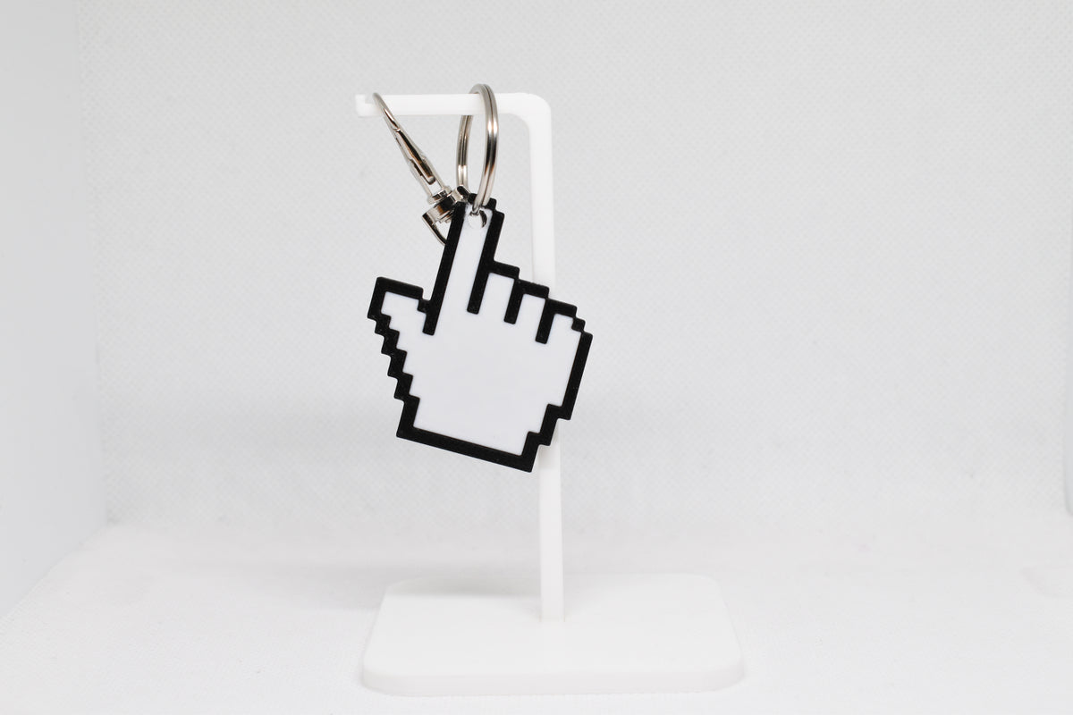 3D printed pixelated pointing hand pointer cursor keychain hanging on a white display stand by LayerPlay