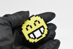 Hand in black glove holding 3D printed pixel smiling face emoji keychain front view detail by LayerPlay