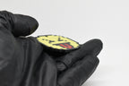 Side angle view showing 3D layered pixel detail and thickness of pixelated squinting face emoji keychain by LayerPlay