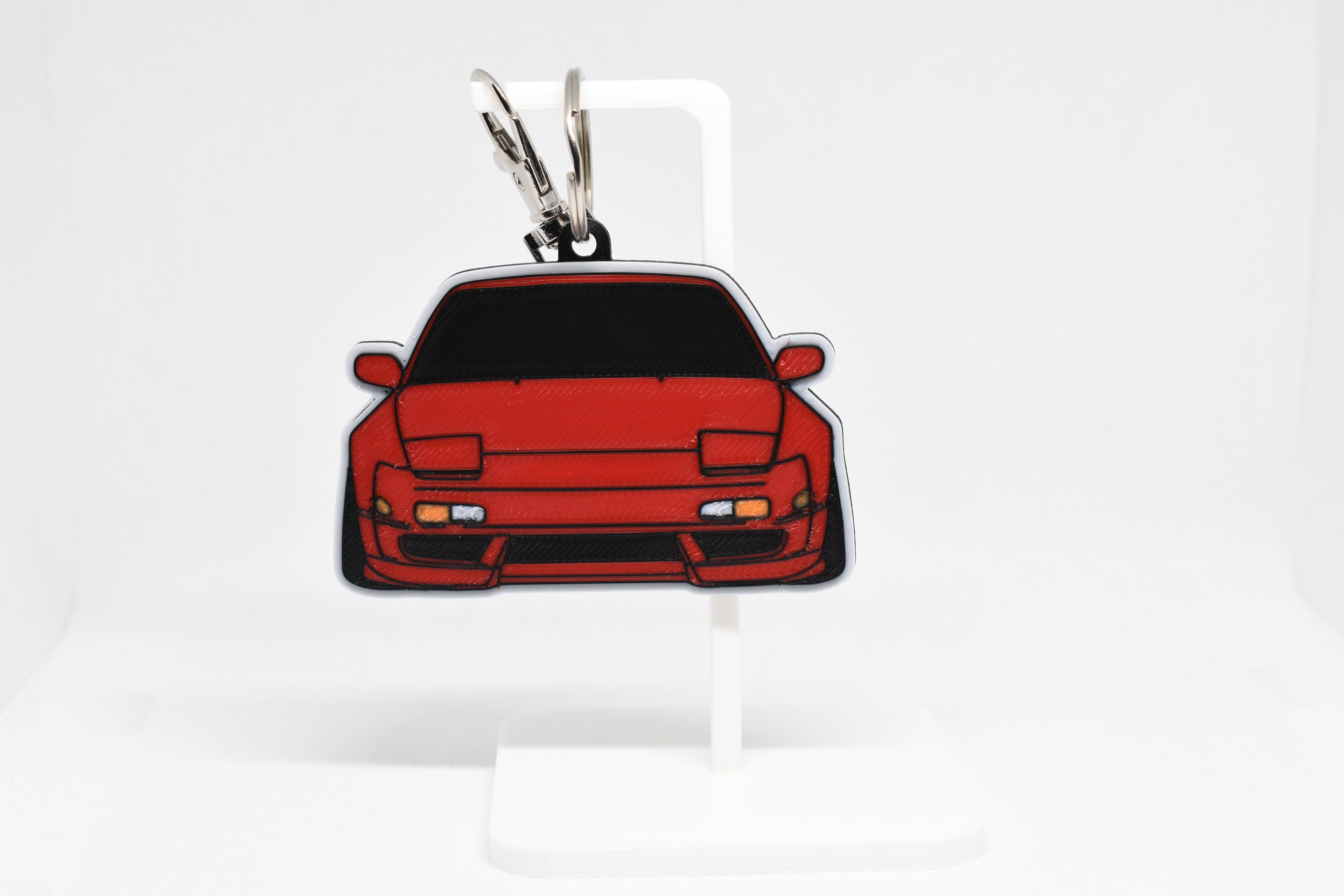 Pocket Motors 240SX S13 keychain displayed on a white stand with metal ring and clip.